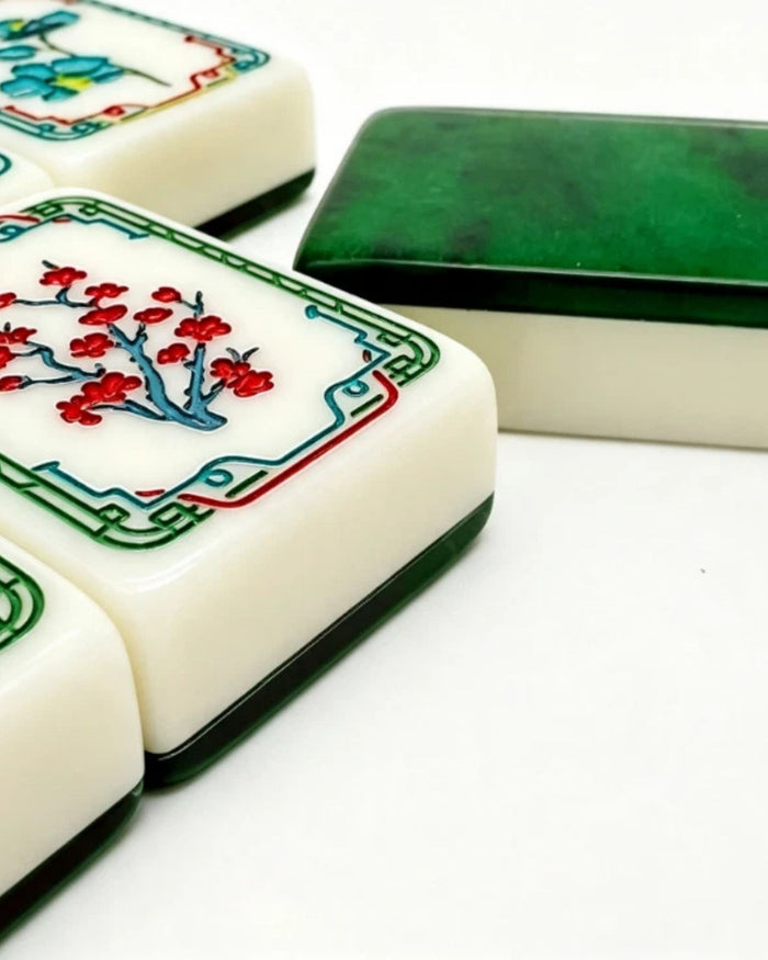 Close-up of mahjong tiles with colorful fronts and green tile backs