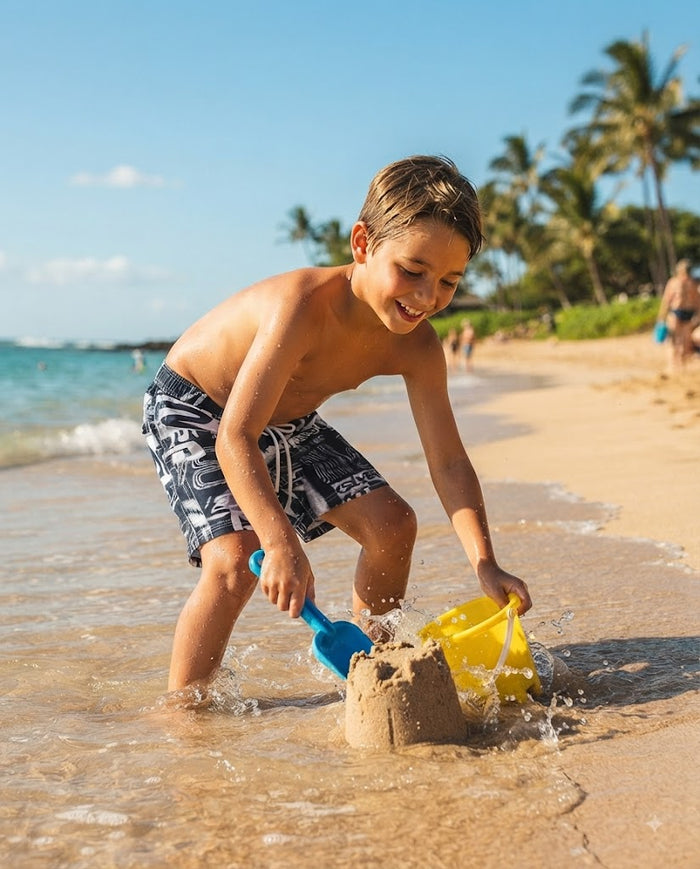 Kids swim shorts worn by boy: dark navy with white abstract pattern, elastic waist and ties