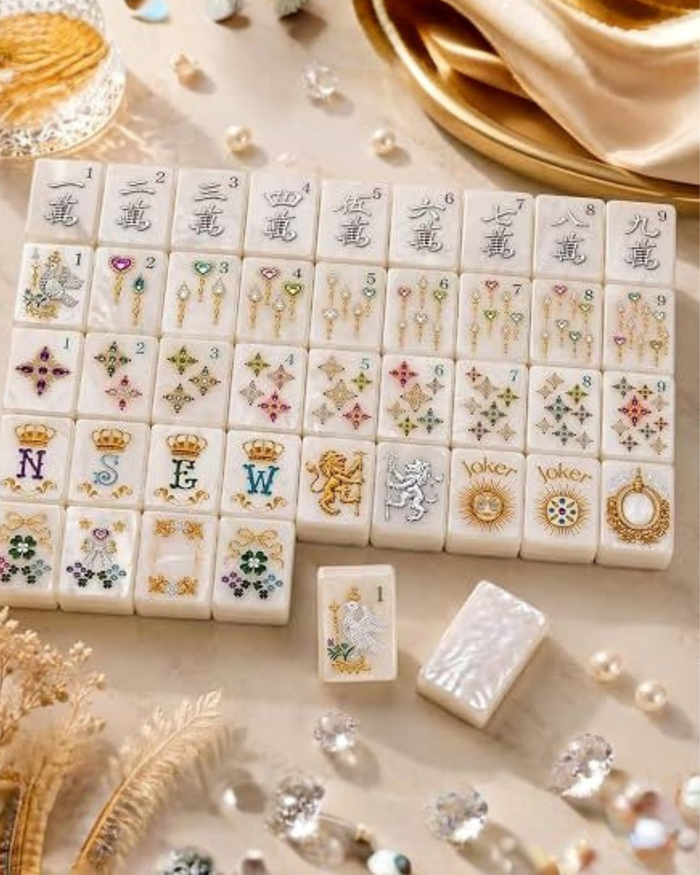 Wide view of pearlescent mahjong tiles with numbered suits and gold “Joker” tiles
