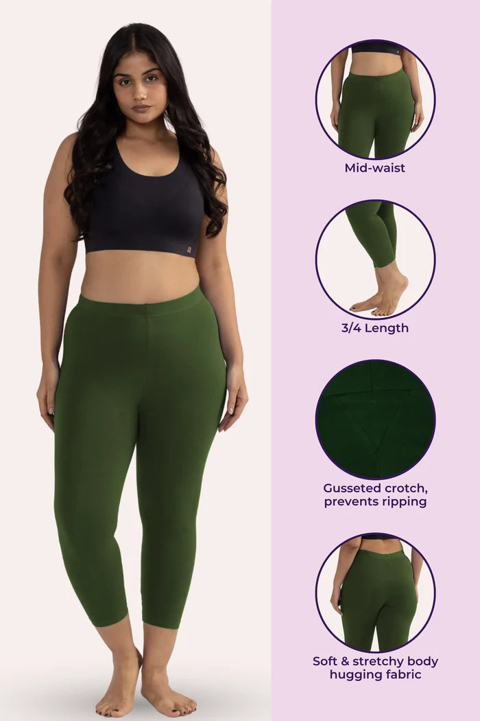 Woman wearing green cropped leggings with product features on a pink background