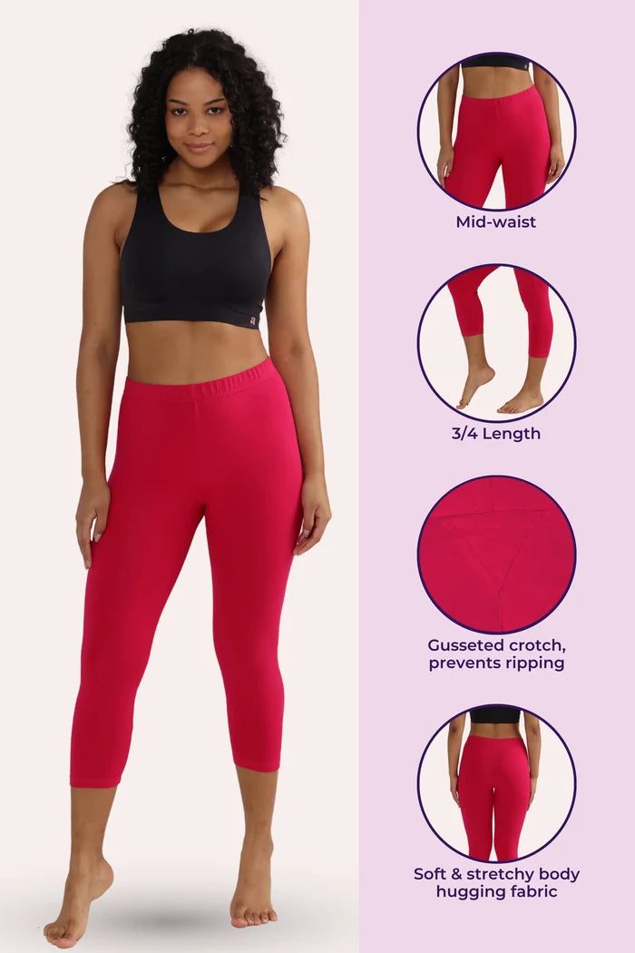 Woman wearing dark pink cropped leggings with product features on a pink background