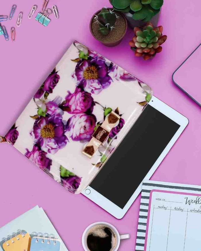 Light pink tablet carry bag with purple floral print, bow clasp, and gold zipper