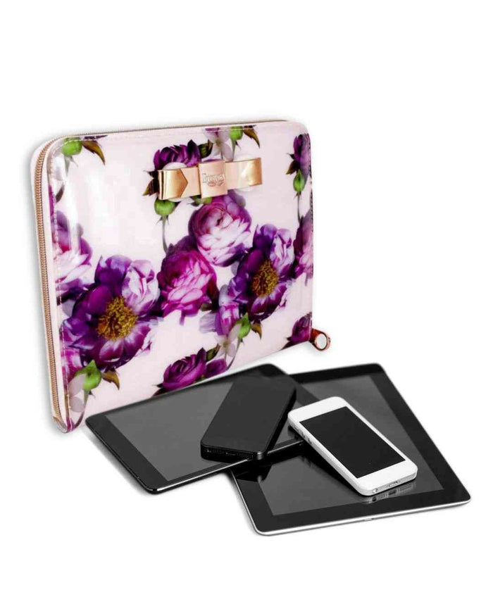 Light pink tablet carry bag with purple floral print, bow clasp, and gold zipper edge