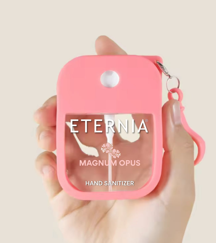 Pink hand sanitizer keyring pouch held in hand, with ETERNIA Magnum Opus label