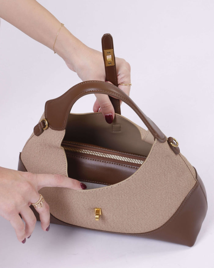 Beige tweed shoulder bag held open, brown interior lining, gold zipper and rings