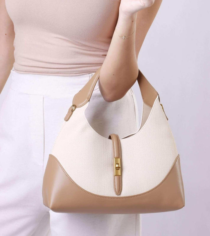 Cream and tan shoulder bag with front strap tab and gold buckle detail