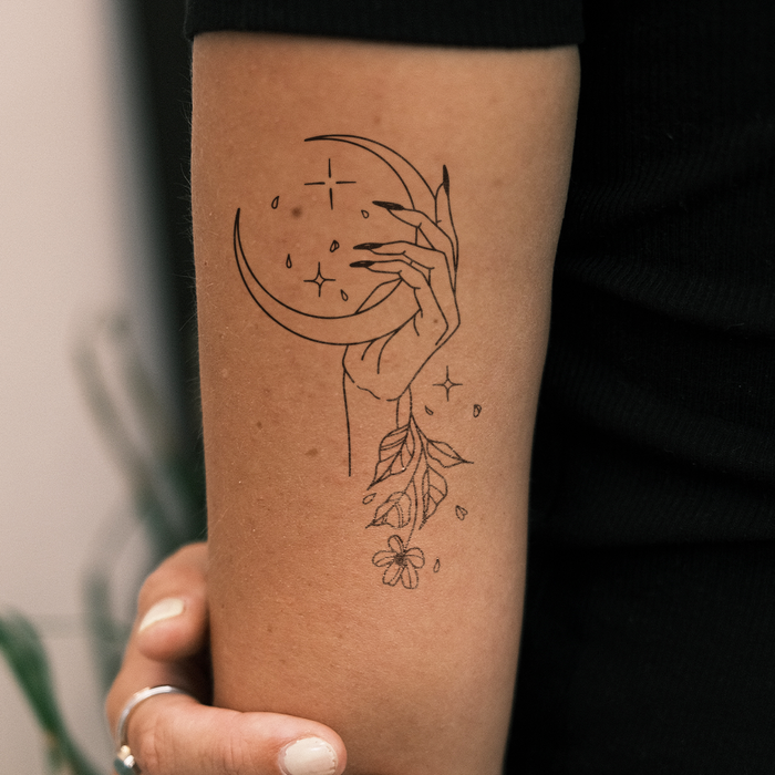Hand hält Mond und Blume
