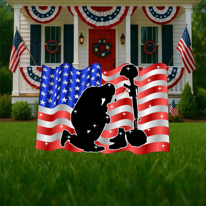 Hand-painted kneeling soldier silhouette before battlefield cross with American flag background, handcrafted military memorial yard art