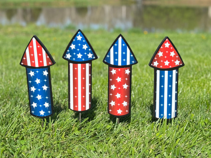 Set of four outdoor red, white and blue outdoor firework shaped yard art signs.  Patriotic lawn decor for spring, summer, 4th of July and all summer holidays.