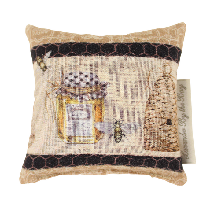 A beige lavender closet sachet with an embroidered design of a honey jar, a beehive, and bees