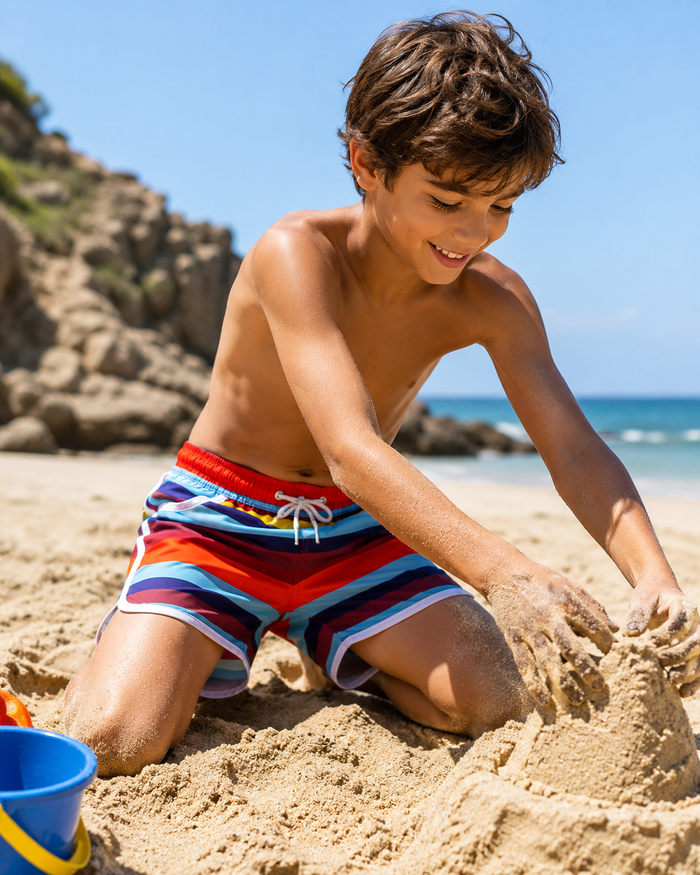 Boys striped swim shorts on a beach, elastic waistband with white drawstring