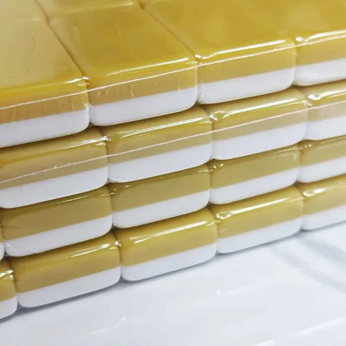 Mahjong tile set stack with yellow-and-white tile backs and glossy finish