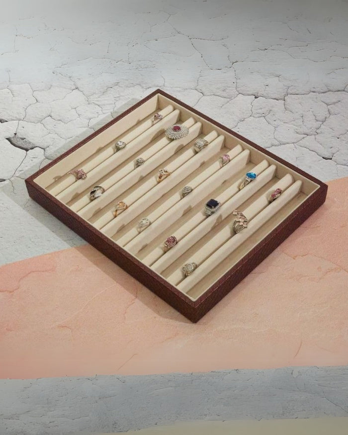 Brown jewellery tray with cream dividers, lined with decorative rings