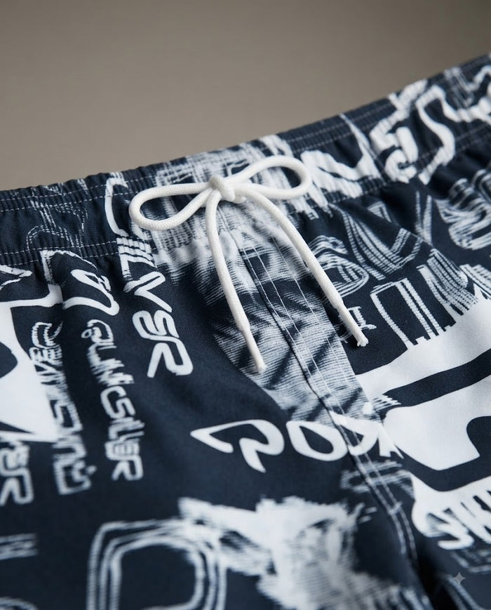 Kids swim shorts close-up: dark navy with white abstract print, elastic waistband and white drawstring